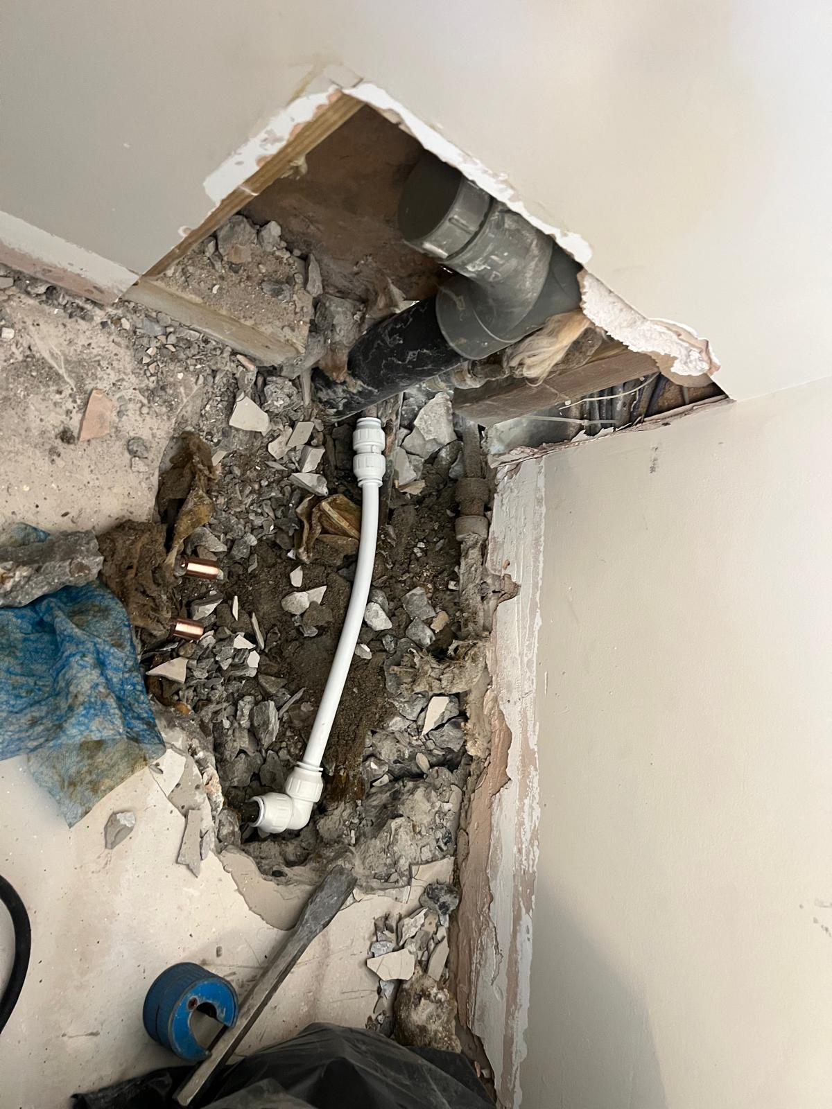 Concealed pipework repaired and chased back into a plastered wall